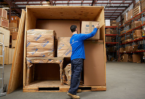 Warehouse worker filling a storage container